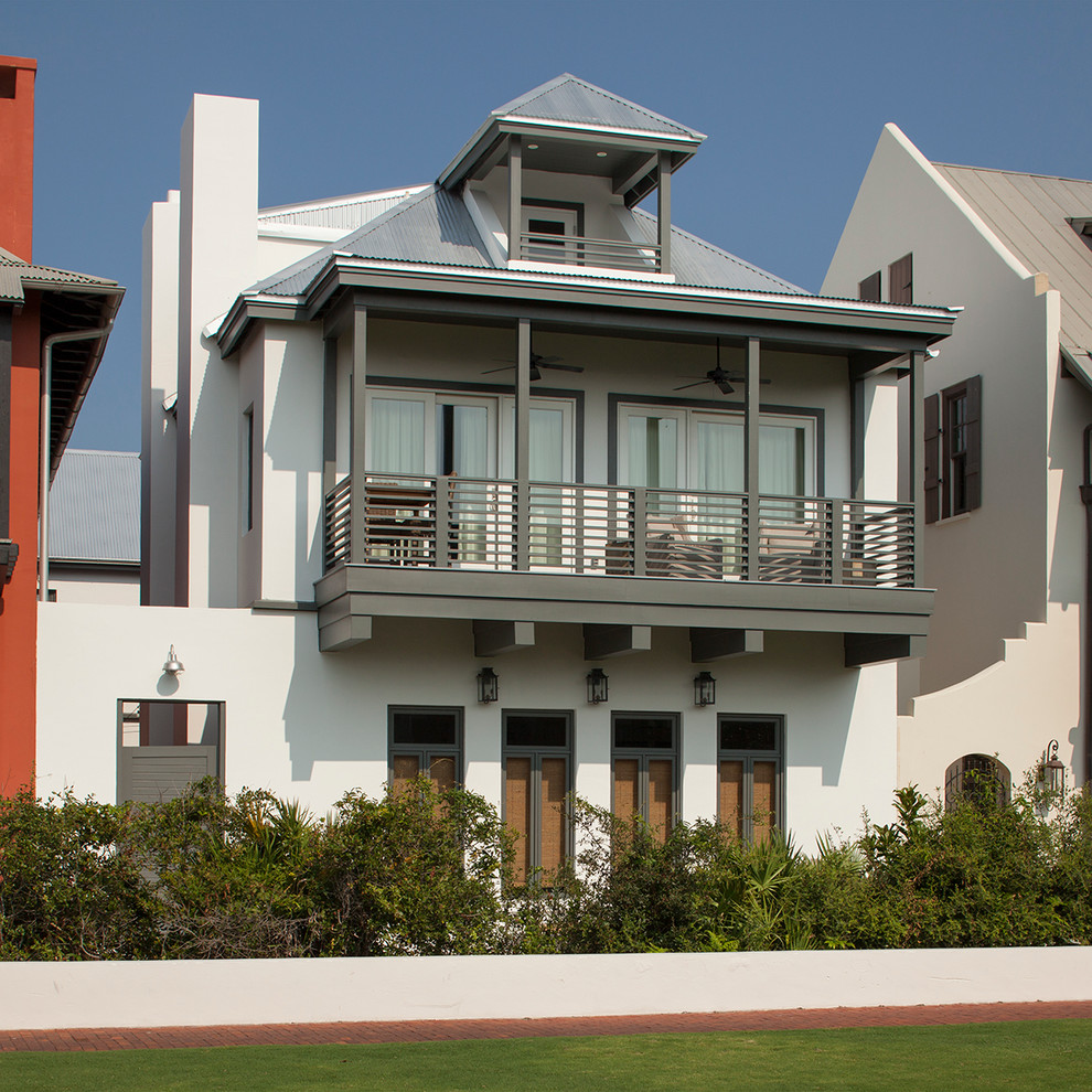 Large beach style white three-story stucco exterior home photo in Jacksonville with a hip roof