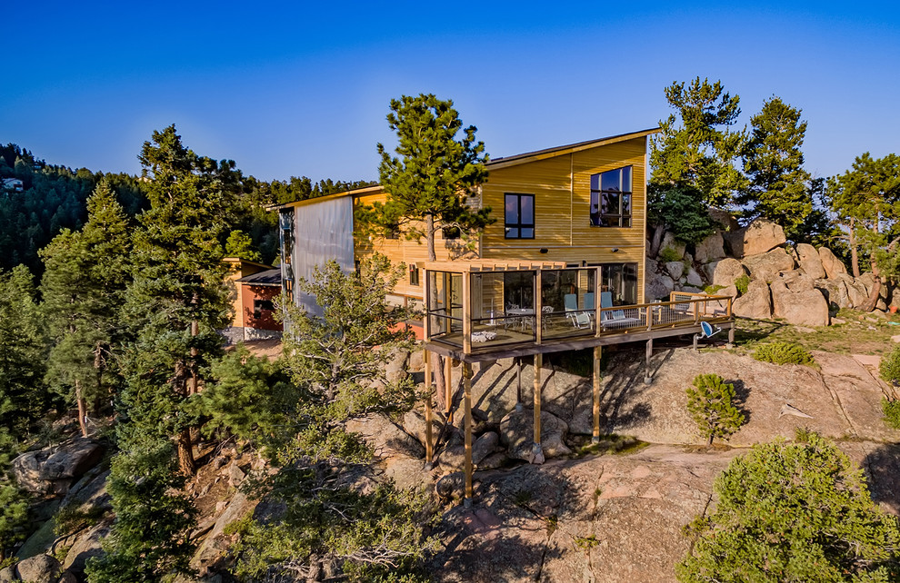 Mid-sized contemporary yellow two-story wood house exterior idea in Denver with a shed roof