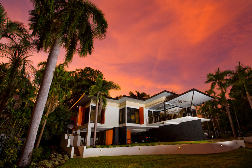 This is an example of a medium sized and white world-inspired two floor house exterior in Darwin with mixed cladding and a flat roof.