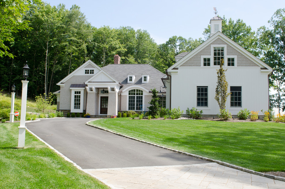 Cette photo montre une grande façade de maison beige nature à un étage avec un revêtement mixte, un toit à deux pans et un toit en shingle.