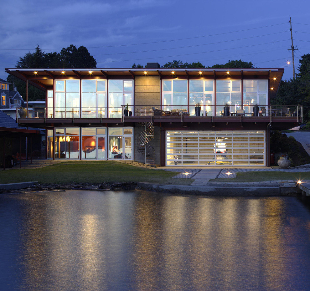 Cette image montre une façade de maison multicolore design en verre à un étage avec un toit plat.