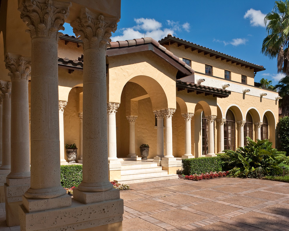 Ispirazione per la villa ampia beige mediterranea a due piani con rivestimento in stucco, tetto a capanna e copertura in tegole