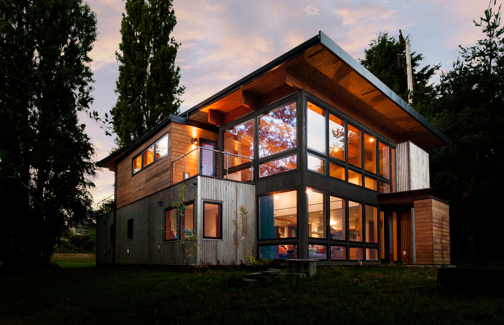 На фото: двухэтажный, коричневый частный загородный дом среднего размера в стиле лофт с облицовкой из металла, плоской крышей и крышей из смешанных материалов с