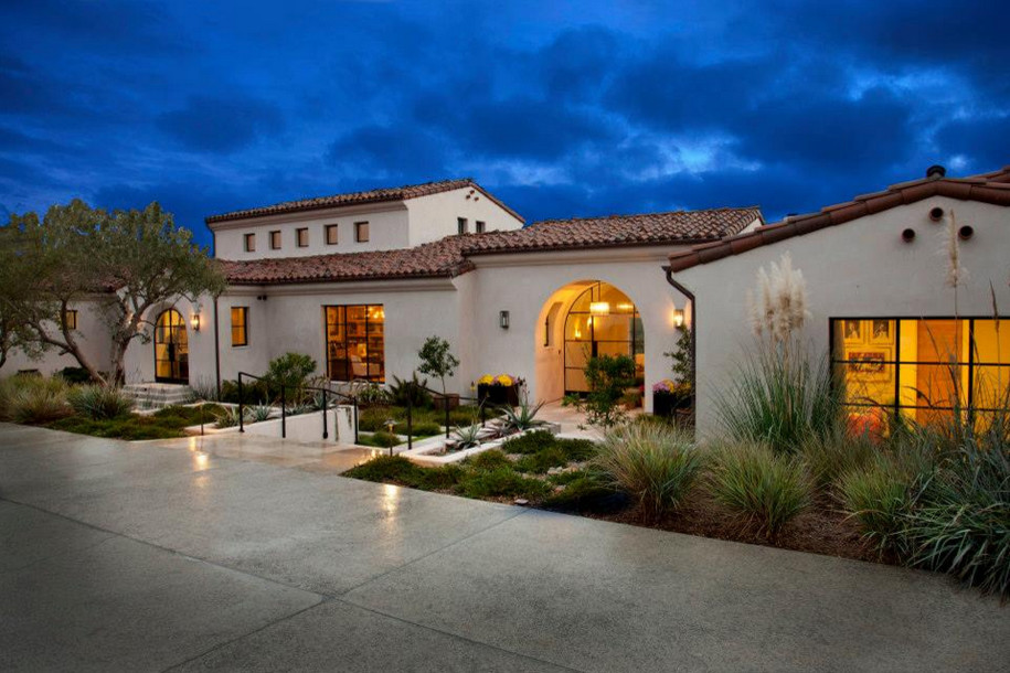 Large tuscan white one-story stucco house exterior photo in San Diego with a tile roof