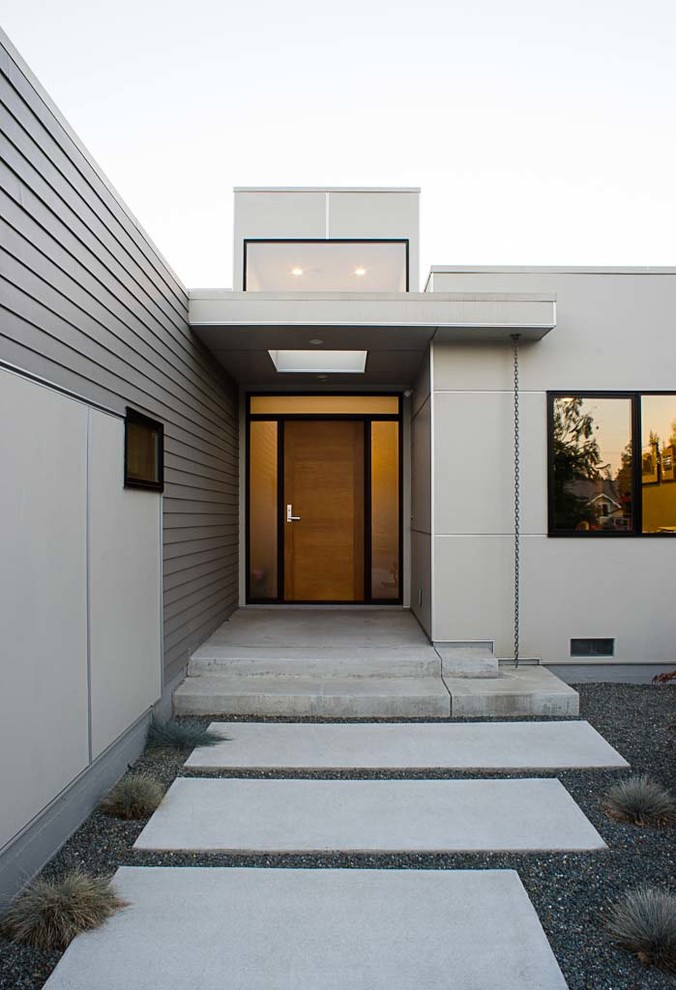Inspiration pour une façade de maison grise minimaliste de taille moyenne et de plain-pied avec un revêtement mixte et un toit plat.