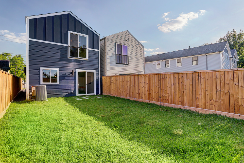 На фото: маленький, двухэтажный, синий частный загородный дом в стиле неоклассика (современная классика) с облицовкой из ЦСП, двускатной крышей и крышей из гибкой черепицы для на участке и в саду