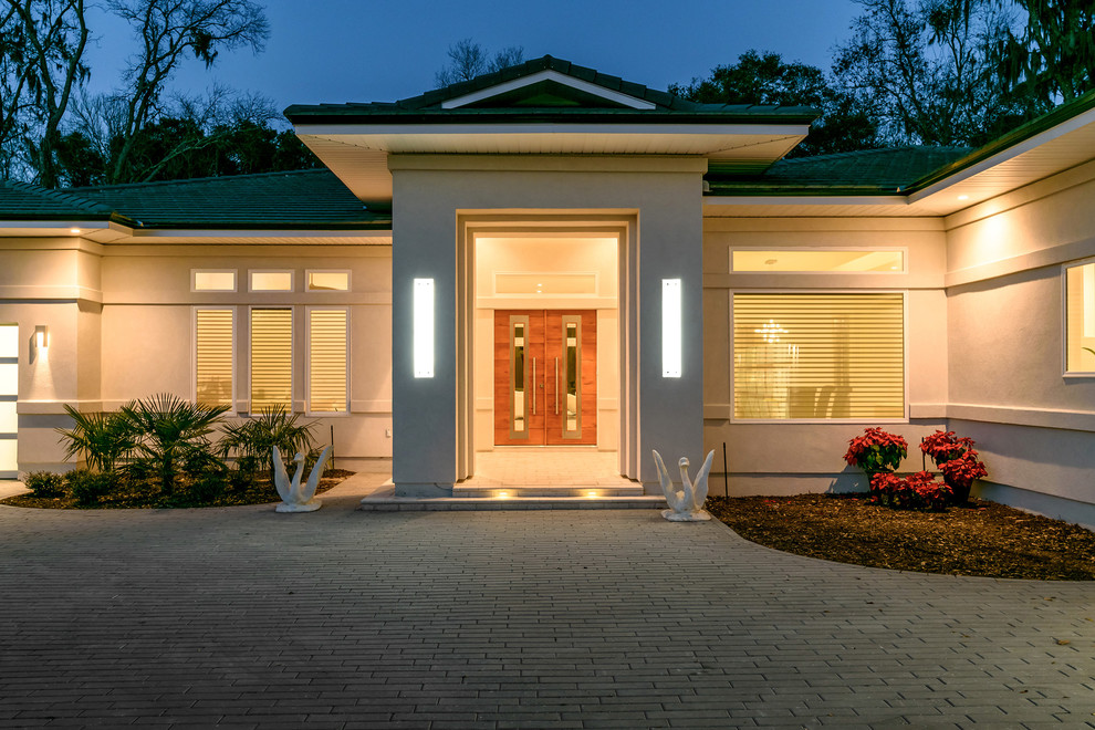 Mittelgroßes, Einstöckiges Modernes Haus mit Putzfassade, weißer Fassadenfarbe und Walmdach in Jacksonville