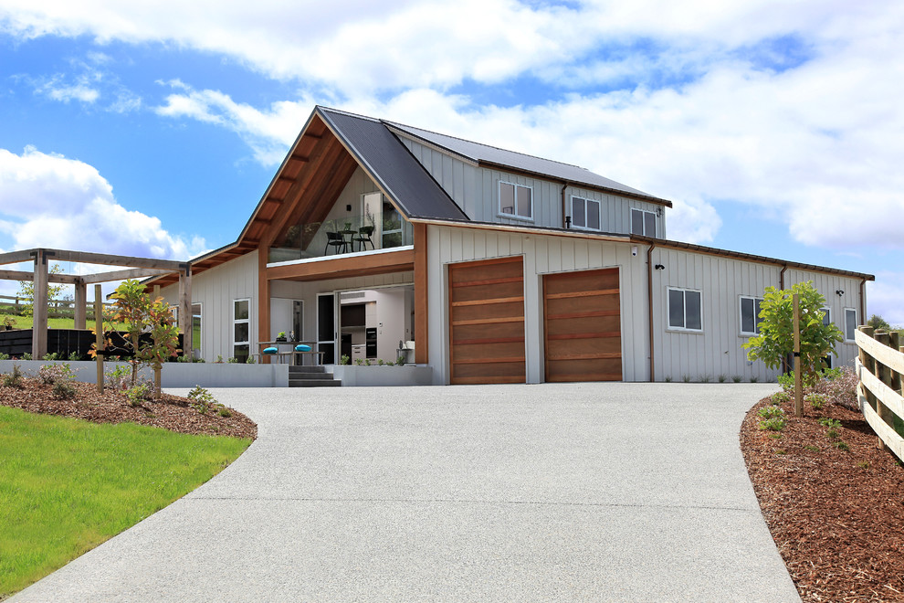 Inspiration pour une grande façade de grange rénovée beige design en bois à un étage avec un toit à deux pans.