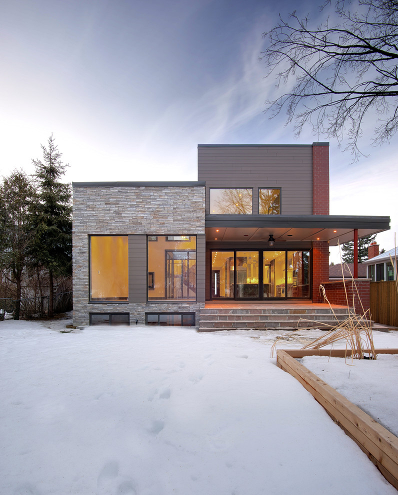 Inspiration for a large contemporary red two-story mixed siding flat roof remodel in Toronto