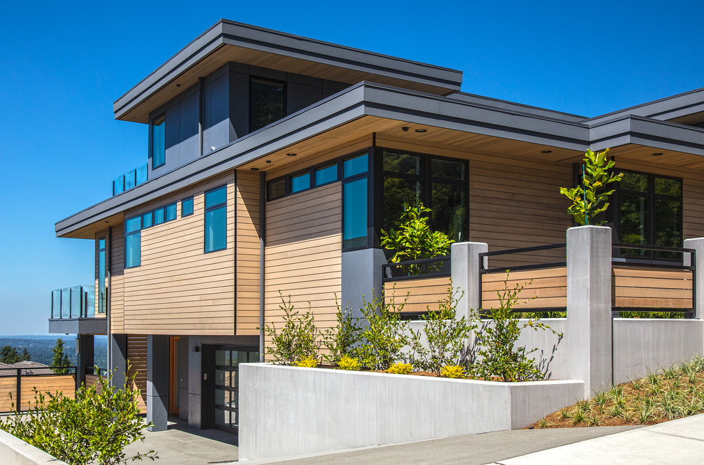 Imagen de fachada de casa multicolor actual grande de dos plantas con revestimientos combinados, tejado plano y tejado de metal
