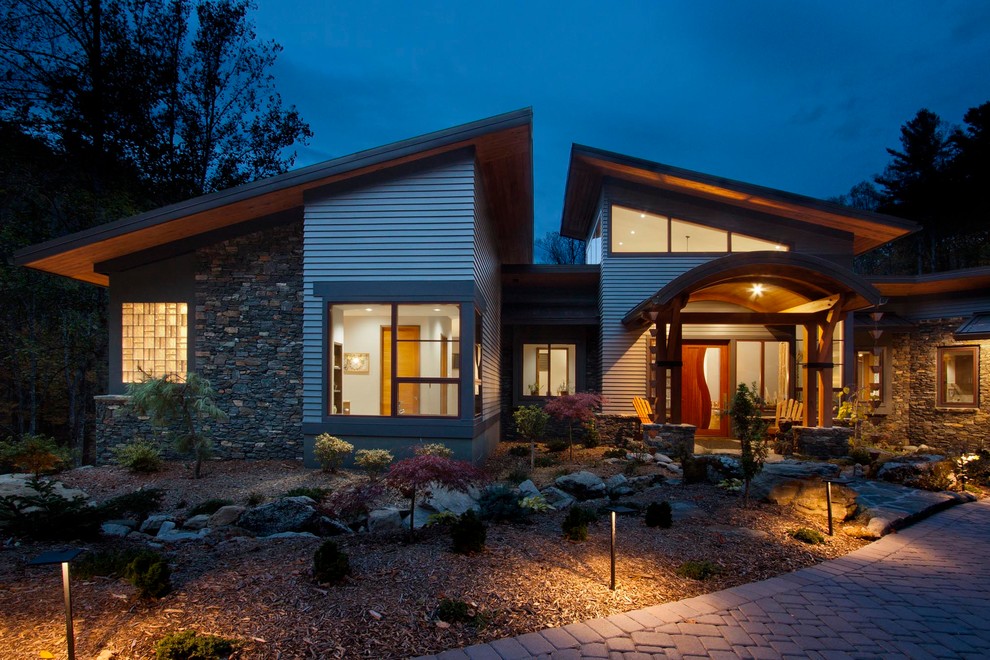 Aménagement d'une grande façade de maison multicolore contemporaine à un étage avec un revêtement mixte, un toit en métal et un toit en appentis.