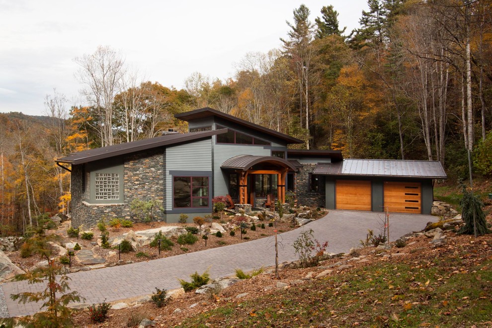 Стильный дизайн: большой, двухэтажный, разноцветный частный загородный дом в современном стиле с комбинированной облицовкой, плоской крышей и металлической крышей - последний тренд