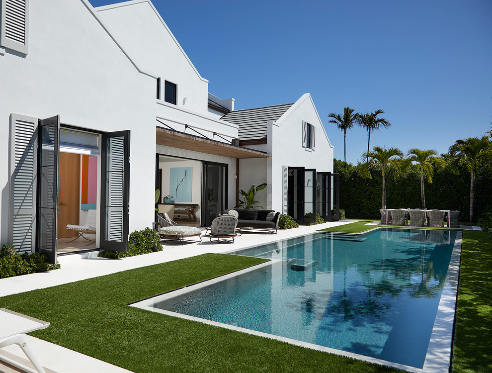 Example of a mid-sized beach style white two-story stucco exterior home design in Miami with a shingle roof