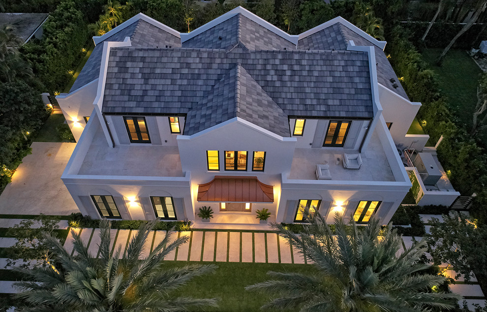 Пример оригинального дизайна: большой, двухэтажный, белый частный загородный дом в морском стиле с облицовкой из цементной штукатурки, двускатной крышей и крышей из гибкой черепицы