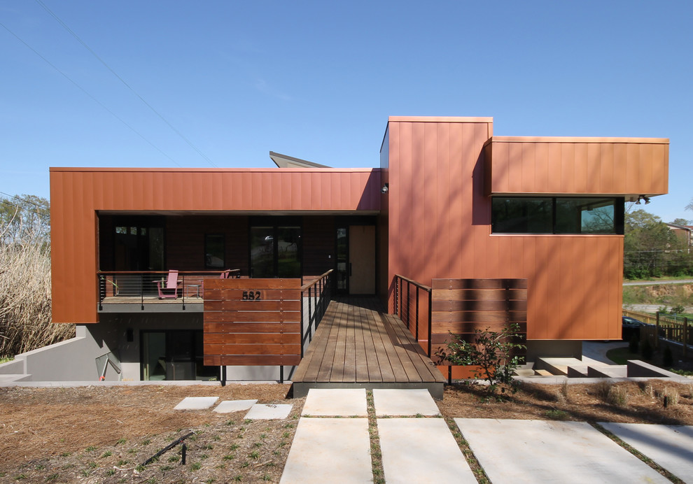 Ejemplo de fachada marrón contemporánea de dos plantas con revestimiento de metal y tejado plano