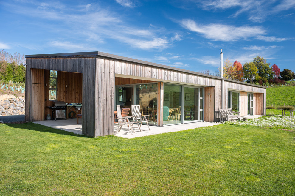 Einstöckige Moderne Holzfassade Haus mit beiger Fassadenfarbe und Flachdach in Sonstige