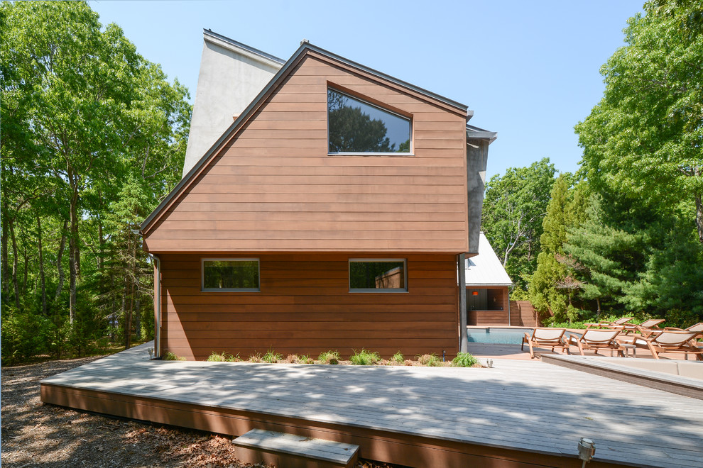 Idées déco pour une façade de maison marron contemporaine en bois.