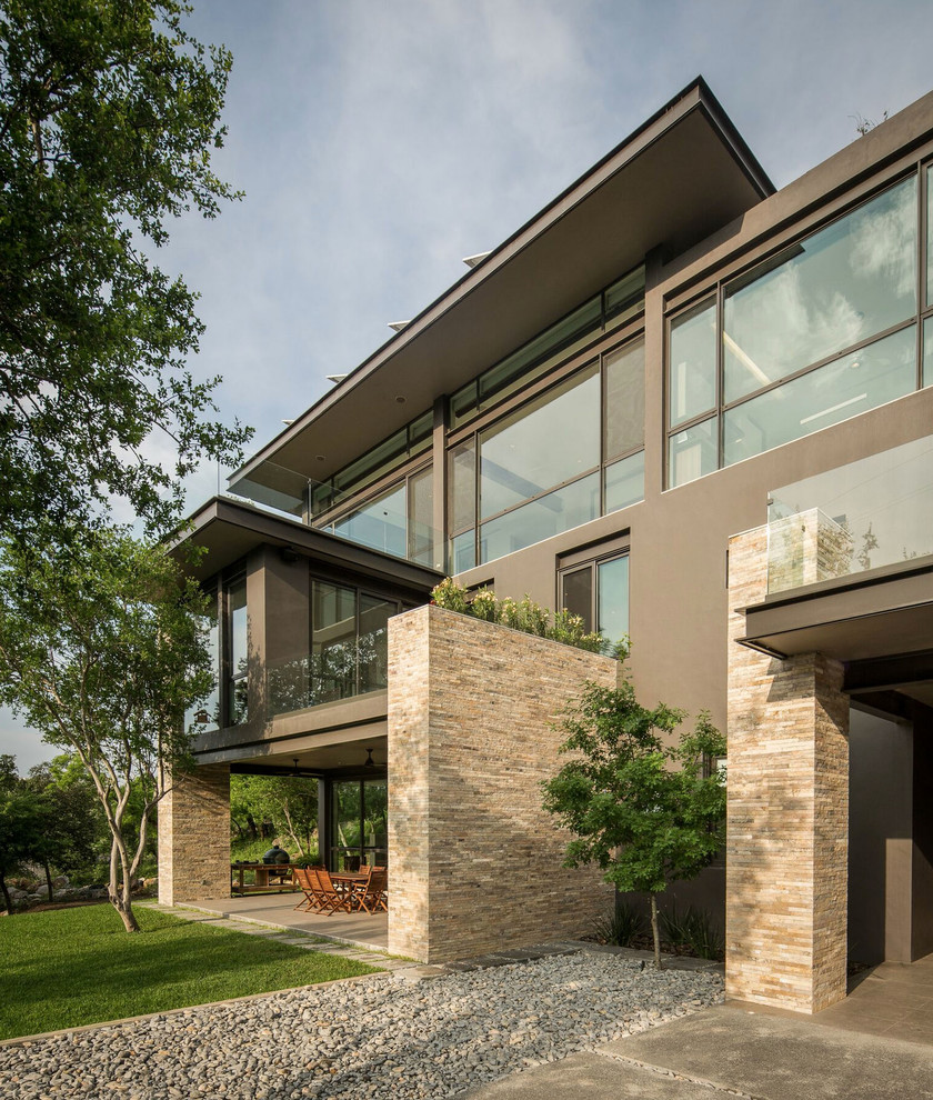 Imagen de fachada gris contemporánea de dos plantas con revestimientos combinados y tejado plano