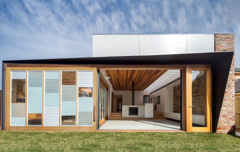Exempel på ett modernt hus, med allt i ett plan, blandad fasad och platt tak