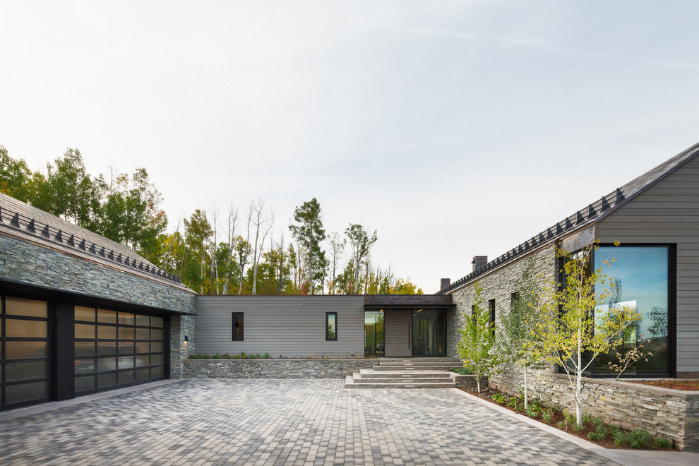 Идея дизайна: серый, одноэтажный частный загородный дом в современном стиле с комбинированной облицовкой и двускатной крышей