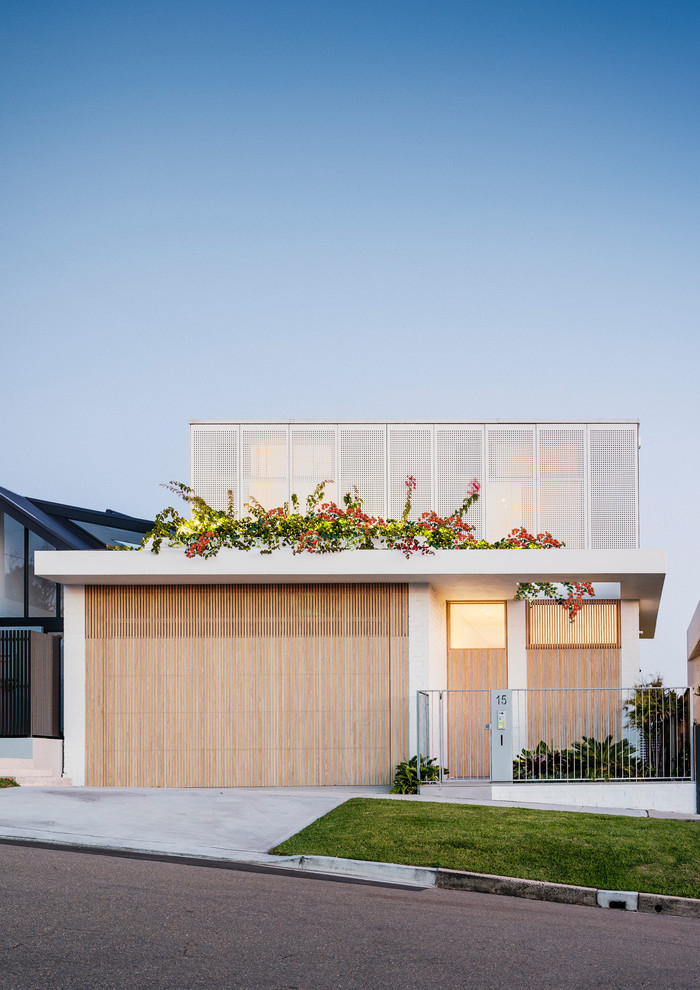 This is an example of a white contemporary two floor detached house in Sydney with a flat roof.
