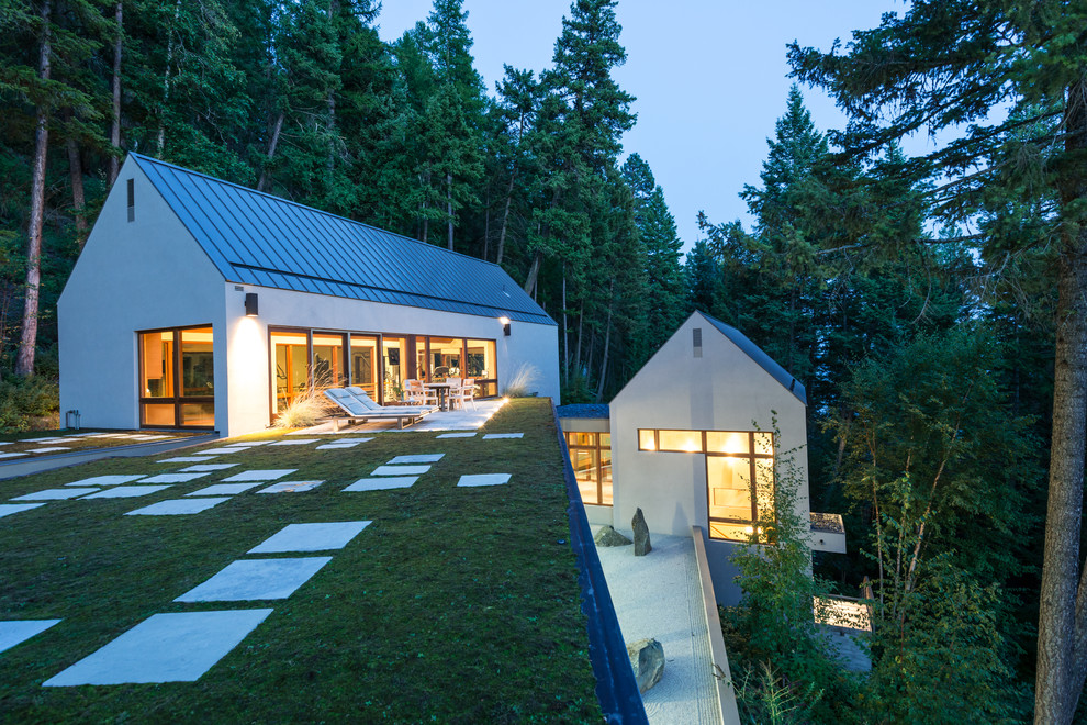 Exemple d'une façade de maison tendance à deux étages et plus avec un toit à deux pans et un toit en métal.