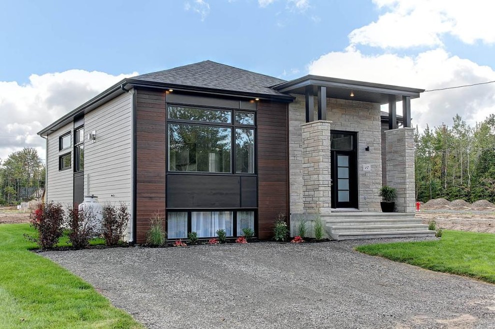 Diseño de fachada gris contemporánea de dos plantas con revestimientos combinados y tejado a cuatro aguas