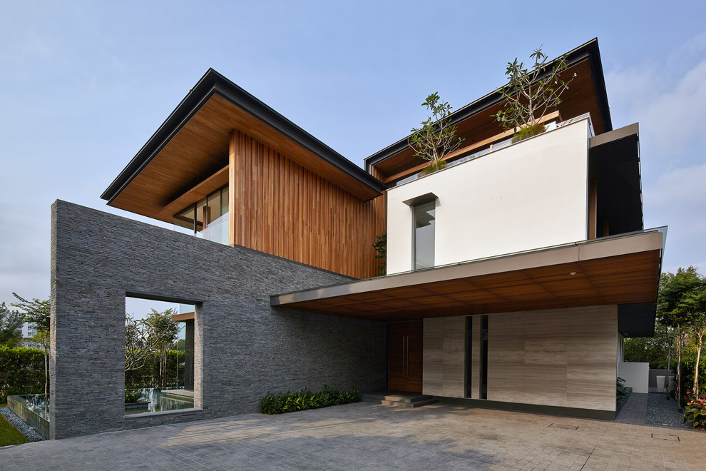Cette photo montre une façade de maison marron tendance avec un revêtement mixte et un toit plat.