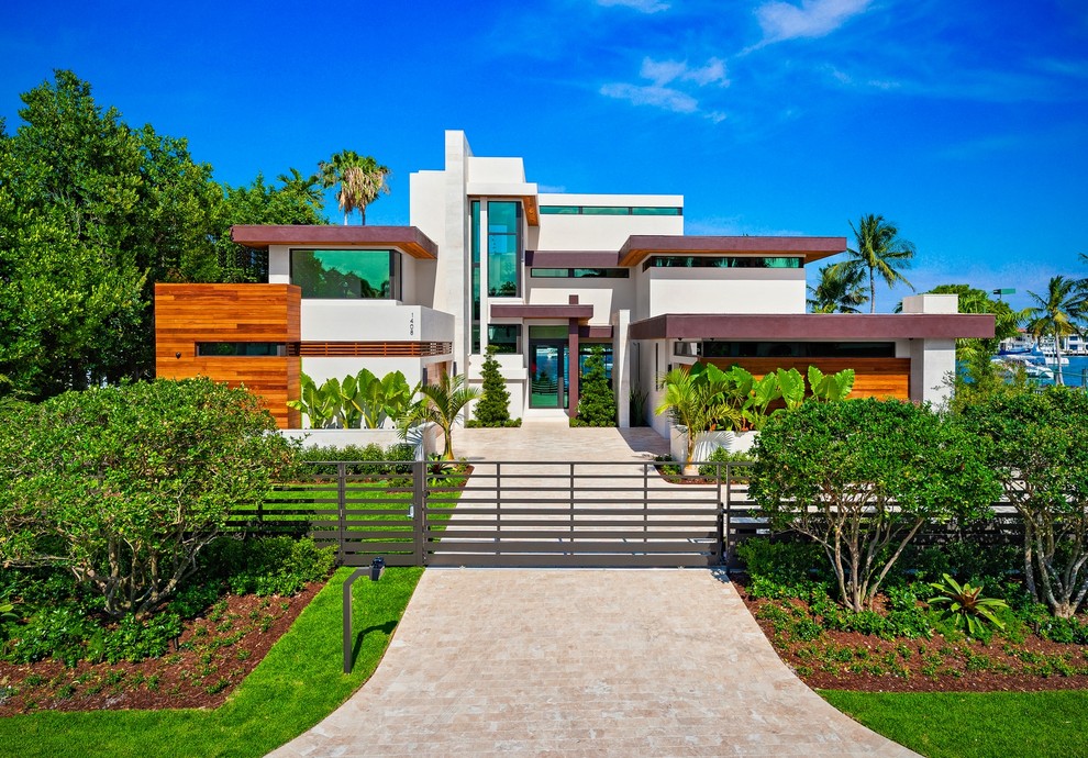 Photo of a beige contemporary detached house in Miami with three floors, mixed cladding and a flat roof.