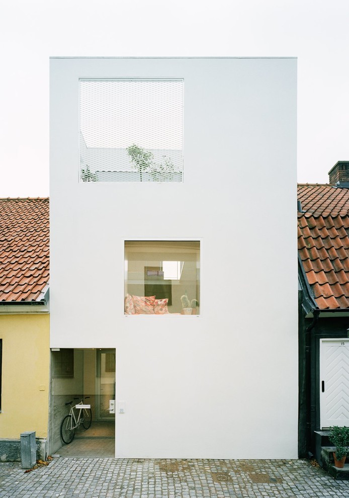 Свежая идея для дизайна: маленький, трехэтажный, белый дом в современном стиле с плоской крышей и облицовкой из самана для на участке и в саду - отличное фото интерьера