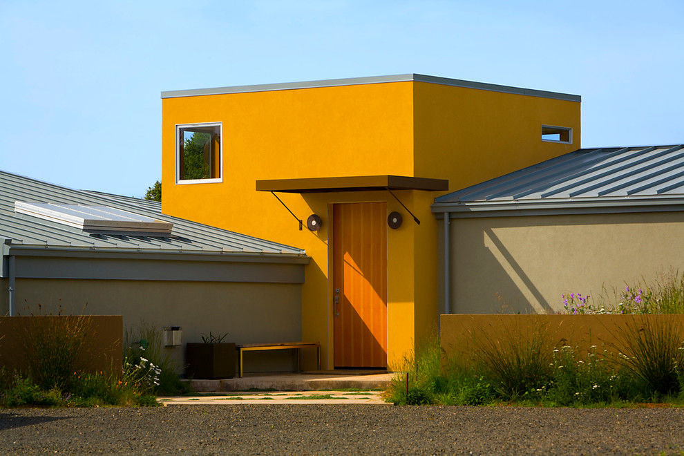 Idées déco pour une façade de maison jaune contemporaine.