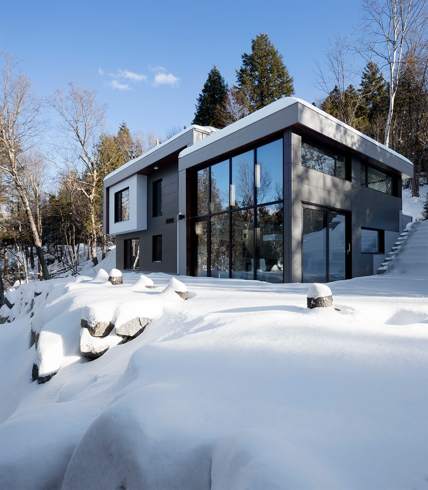 Photo of a gey contemporary two floor house exterior in Montreal with a flat roof.