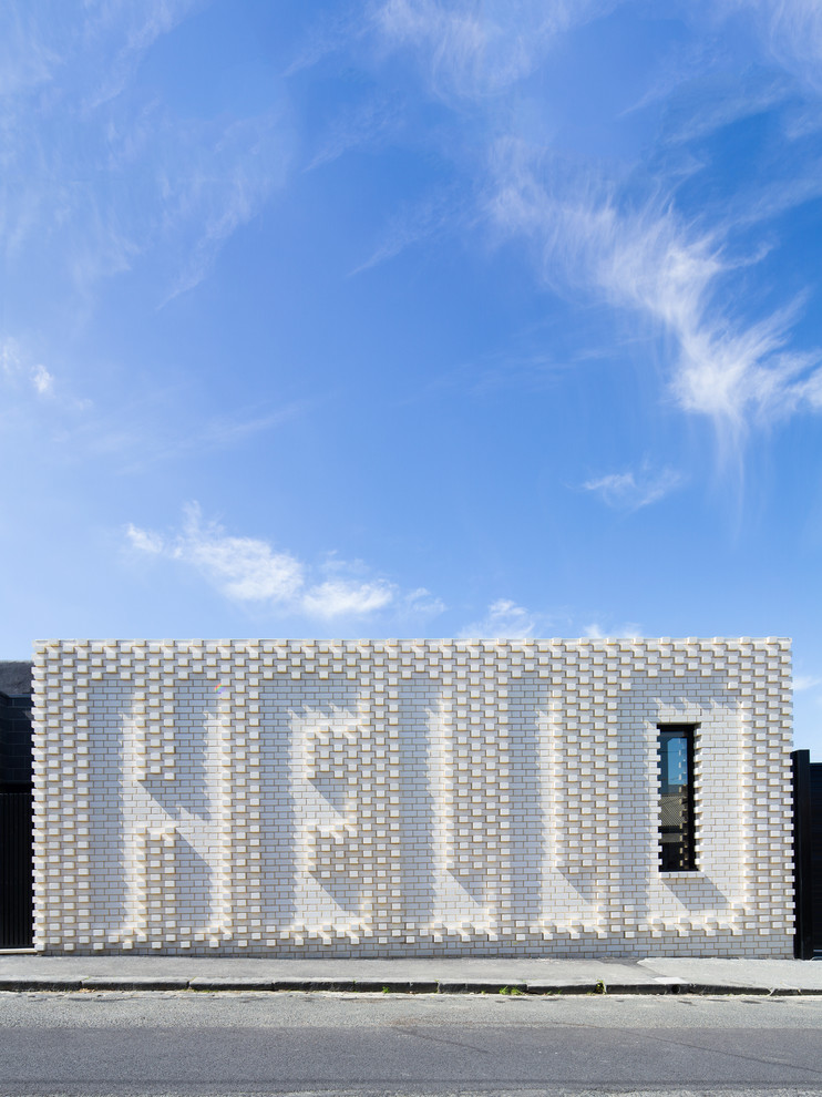 Einstöckiges, Kleines Modernes Haus mit Backsteinfassade, weißer Fassadenfarbe und Flachdach in Melbourne