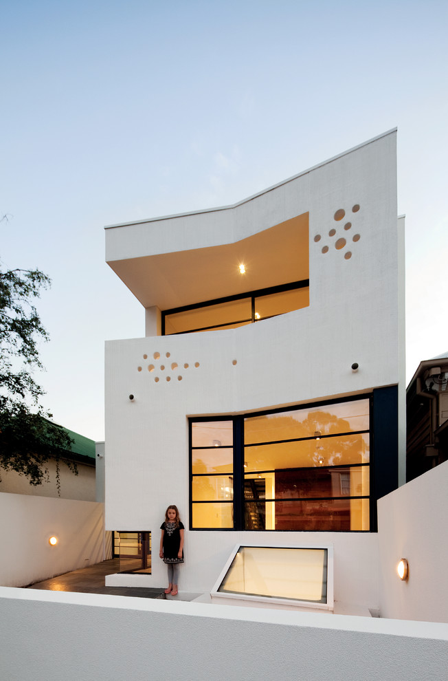 Diseño de fachada blanca contemporánea de tres plantas con revestimiento de estuco y tejado plano