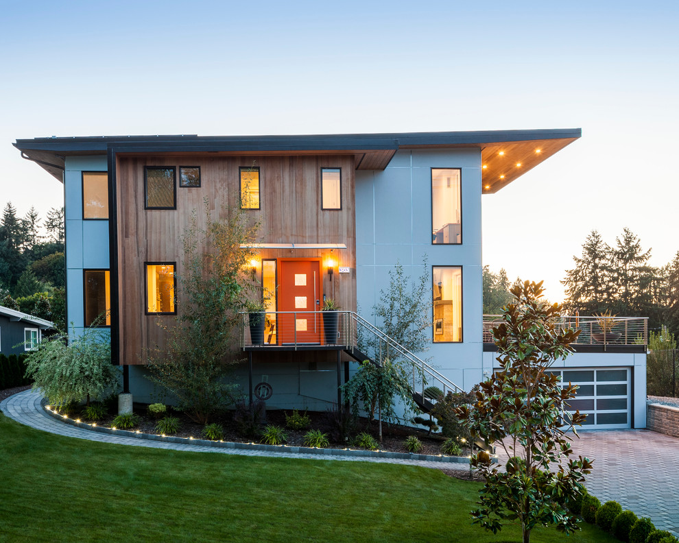 Cette image montre une grande façade de maison design à un étage avec un revêtement mixte.