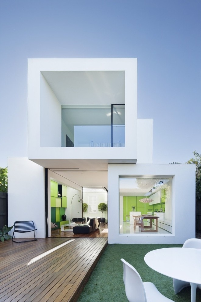 Cette photo montre une façade de maison blanche tendance à un étage avec un toit plat.