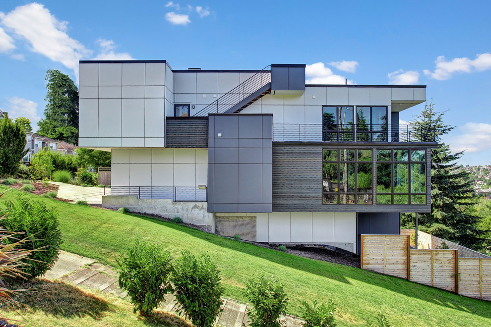 Foto de fachada multicolor actual de tamaño medio de tres plantas con tejado plano y revestimientos combinados