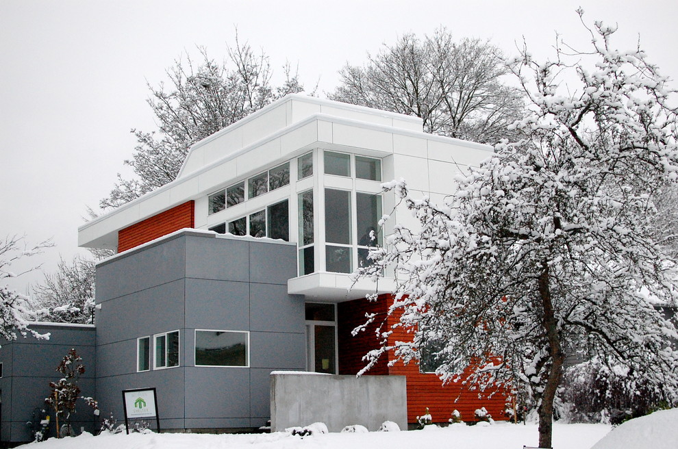 Aménagement d'une façade de maison multicolore contemporaine à un étage et de taille moyenne avec un revêtement mixte et un toit à deux pans.