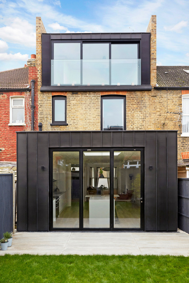 Mittelgroßes, Dreistöckiges Modernes Reihenhaus mit Metallfassade, beiger Fassadenfarbe und Flachdach in London