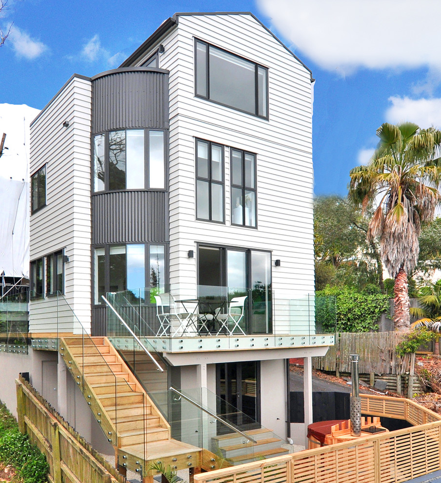 Design ideas for a contemporary house exterior in Auckland with three floors and a pitched roof.