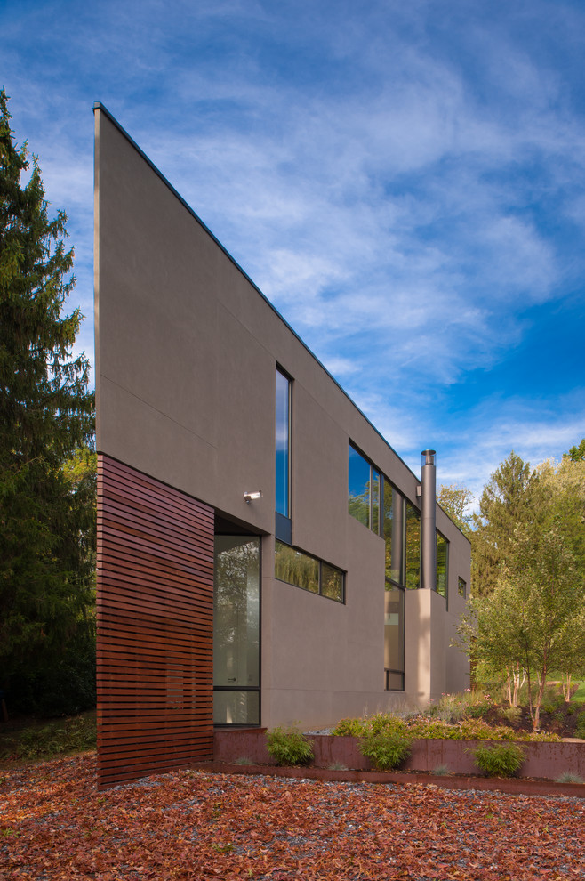 Imagen de fachada marrón actual de dos plantas con revestimientos combinados y tejado plano