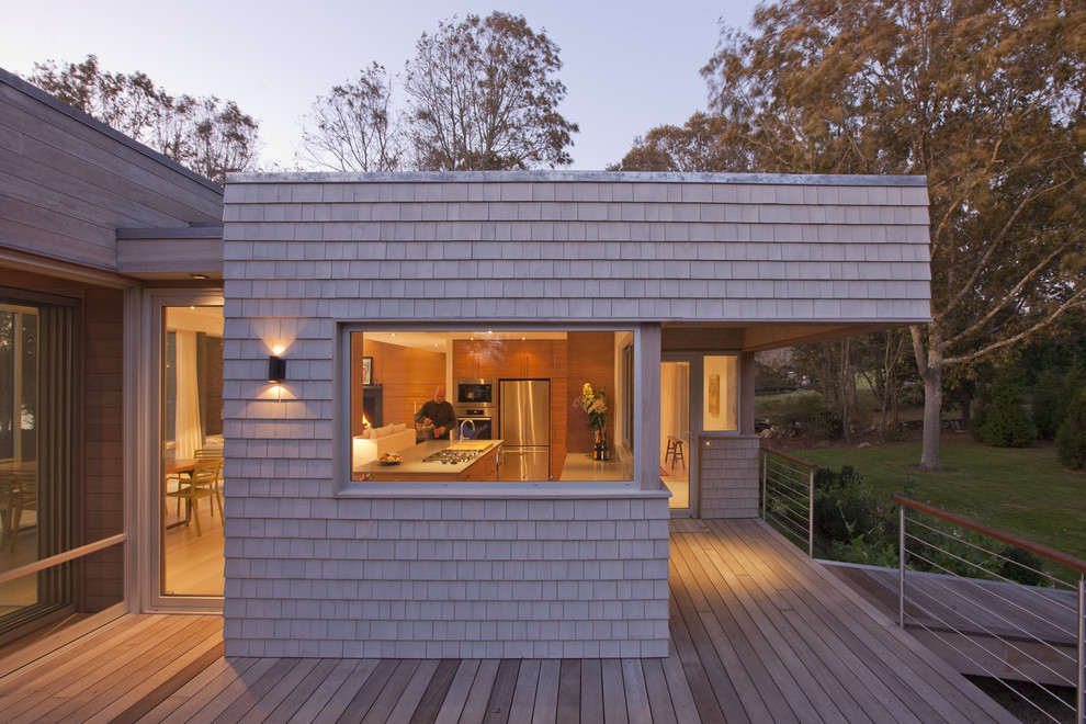 Idée de décoration pour une façade de maison design en bois de plain-pied.
