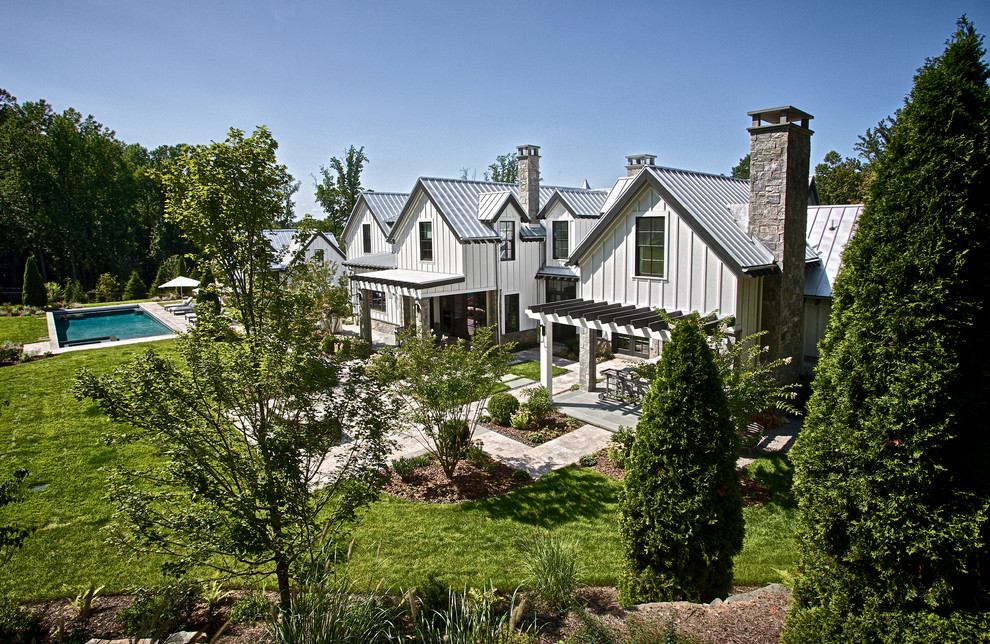 Réalisation d'une très grande façade de maison grise champêtre à un étage avec un revêtement mixte, un toit à deux pans et un toit en métal.