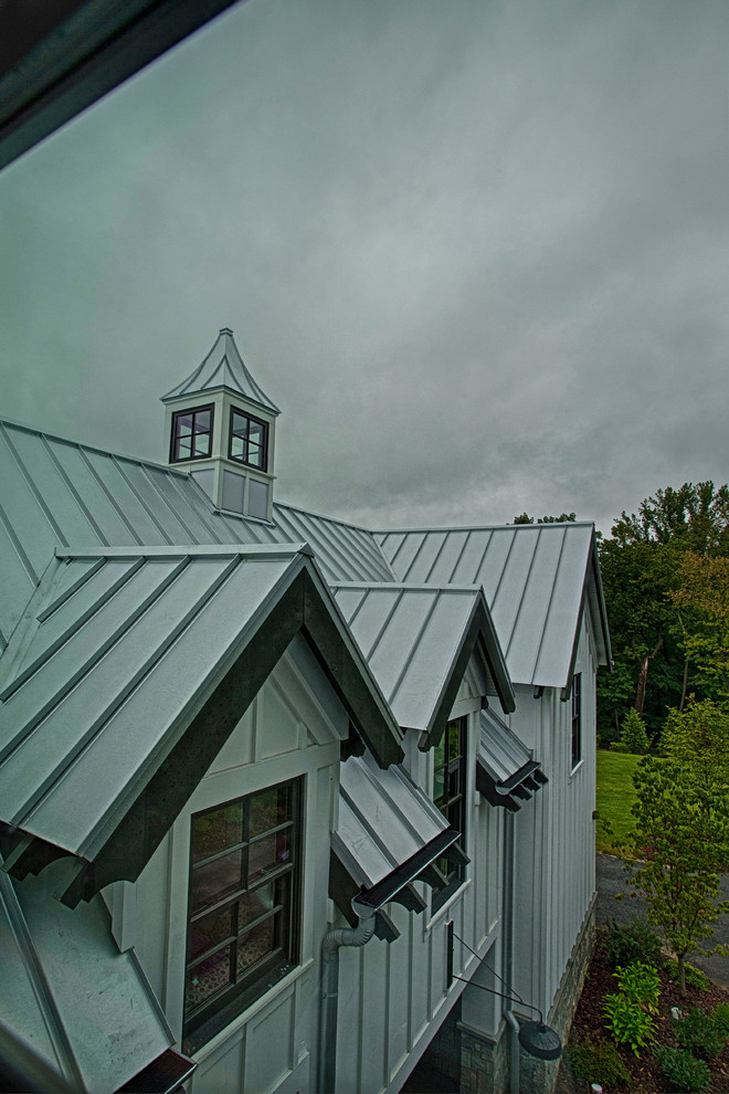 Exemple d'une très grande façade de maison grise nature à un étage avec un revêtement mixte, un toit à deux pans et un toit en métal.