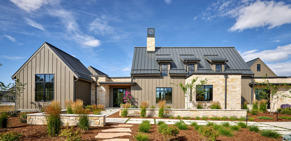 Réalisation d'une grande façade de maison marron champêtre à un étage avec un revêtement mixte, un toit à deux pans et un toit en métal.