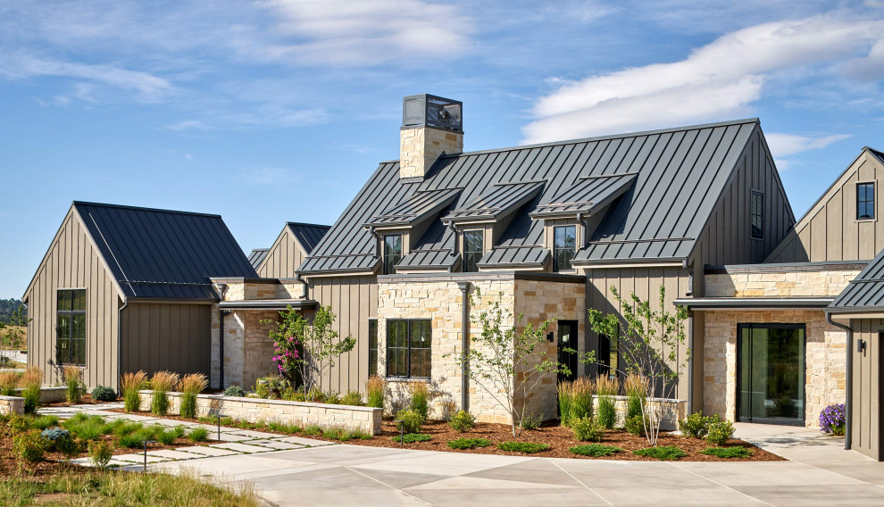 Imagen de fachada de casa marrón de estilo de casa de campo grande de dos plantas con revestimientos combinados, tejado a dos aguas y tejado de metal