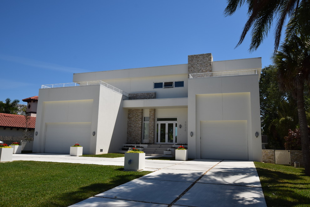 Example of a mid-sized trendy white two-story stucco exterior home design in Tampa
