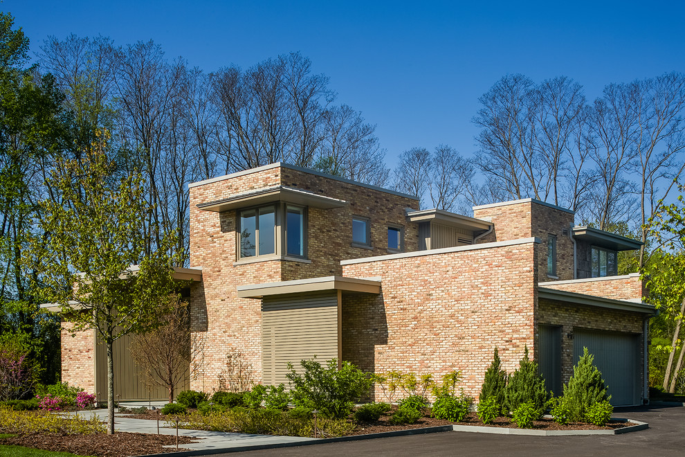 Inspiration för stora moderna bruna hus, med två våningar, tegel, tak i metall och platt tak