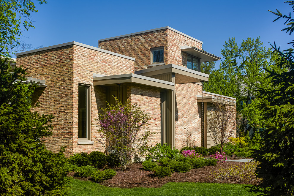 Modelo de fachada de casa rosa minimalista grande de dos plantas con revestimiento de ladrillo y tejado plano