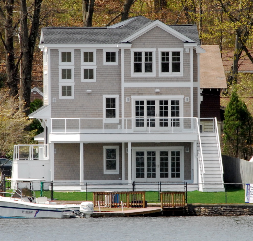 Diseño de fachada gris costera de tamaño medio de tres plantas con revestimiento de madera y tejado a dos aguas